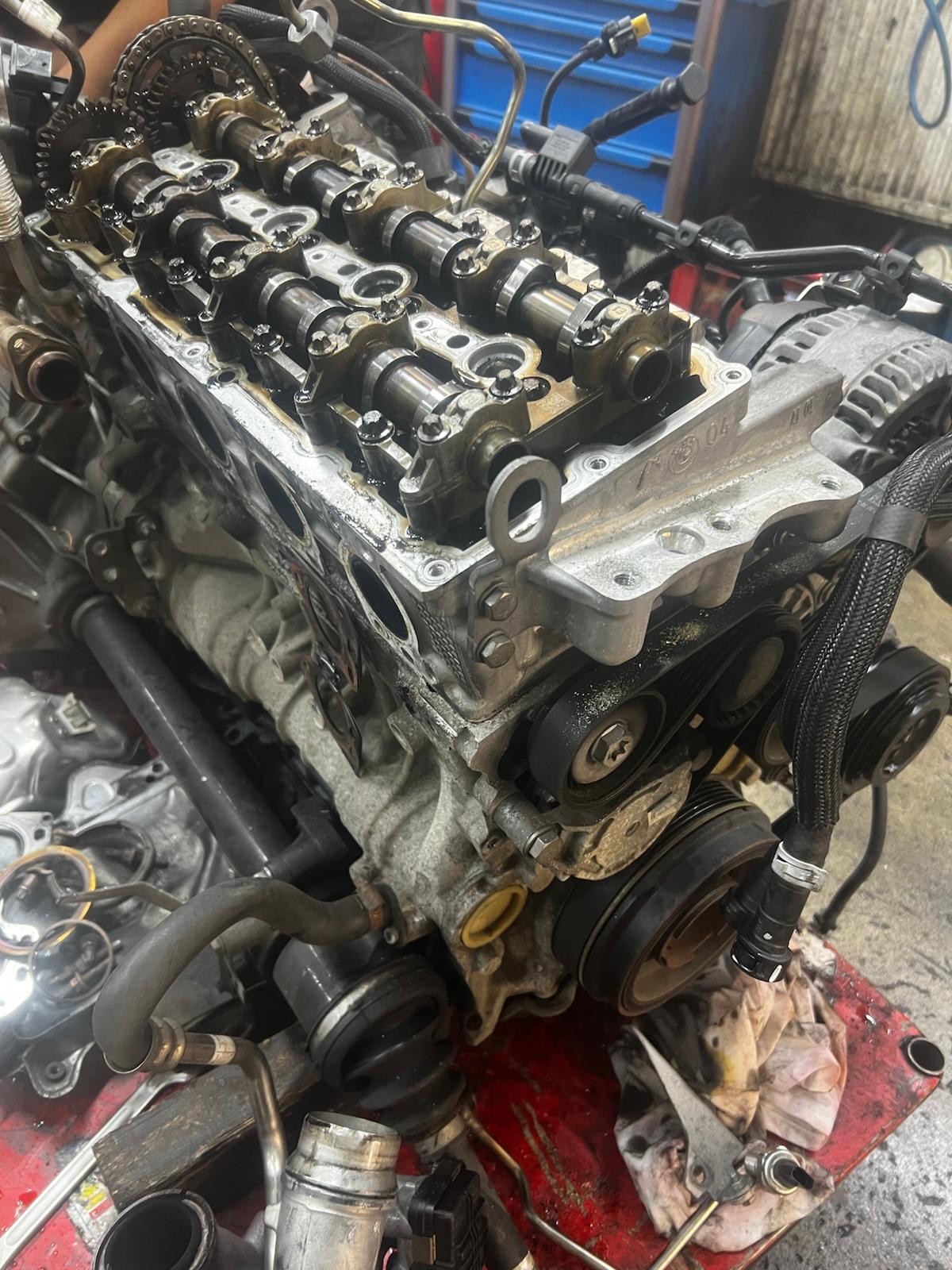 Rozebraný motor BMW s hlavou válců a turbem